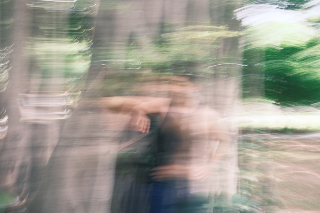 arris standing among trees in an intentionally blurred photograph